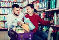 Two friendly adult people in good spirits selecting detergents i Royalty Free Stock Photo