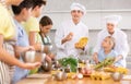 Two friendly chefs giving culinary lesson to group of tweens Royalty Free Stock Photo