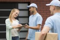 Two friendly couriers and a client Royalty Free Stock Photo