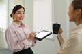 Two friendly female office workers having pleasant conversation, discussing project or sharing news during coffee break Royalty Free Stock Photo