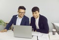 Two friendly male colleagues are working together in office on joint startup project. Royalty Free Stock Photo