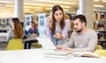 Male and female students preparing for exam together in library Royalty Free Stock Photo