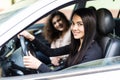 Two attractive friendly young women enjoying a day trip to town viewed through the open window of their car grinning happily at Royalty Free Stock Photo