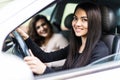 Two attractive friendly young women enjoying a day trip to town viewed through the open window of their car grinning happily at Royalty Free Stock Photo
