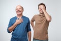 Two friends in casual colorful wear standing and laughing together. Best friends enjoying life. Two men having fun. Royalty Free Stock Photo