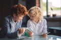 Two friends counting saved money and looking cheerful