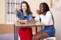 Two women drinking red wine sitting at a table outside a bar. Royalty Free Stock Photo