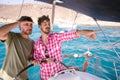 Two friends while driving a boat, a boy points with his hand forward to show something to the other boy. Royalty Free Stock Photo