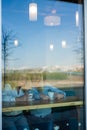 Two friends are enjoying coffee in a coffee shop, looking through a glass with reflections, sitting at a table chatting Royalty Free Stock Photo