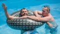 Two friends floating on swimming pool with inflatable rings Royalty Free Stock Photo