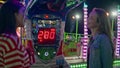 Two friends hang out at funfair machine. Smiling girls playing in amusement park Royalty Free Stock Photo