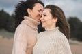 Two friends have fun and enjoy life. The sisters dance and laugh very much. Girls in warm sweaters with a large knitting