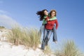 Two friends having piggy back at beach Royalty Free Stock Photo