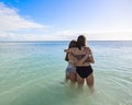 Two friends hug each other while they share a blissful day together on a beautiful scenic beach Royalty Free Stock Photo