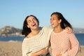 Two friends laughing hilariously on the beach Royalty Free Stock Photo