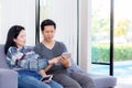 Two friends on line with multiple devices and talking sitting on a sofa in the living room Royalty Free Stock Photo