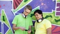 Two friends listening music near graffiti wall. Royalty Free Stock Photo