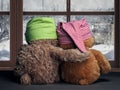 Two friends looking out the window at the falling snow and the city. Toys colorful hats bear cubs. Embrace the . Concept - love,