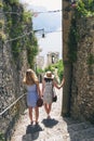 Two friends looking at view of ocean. Girlfriends travelling in Italy on summer beach vacation exploring to discover Royalty Free Stock Photo