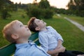 Two brothers in the park are sitting on the bench looking at the sky, being dreamers.