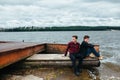 Two friends relaxing on the pier. Royalty Free Stock Photo