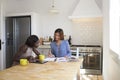 Two friends researching recipes at the kitchen table Royalty Free Stock Photo