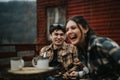 Friends enjoying coffee together on a cozy cabin porch in the mountains. Royalty Free Stock Photo