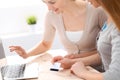 Two friends or sisters talking taking a conversation at the table with laptop