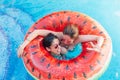 Two friends with sunglasses in watermelon ring lilo. Young women smiling and enjoy the summer at swimming pool. Hand victory sign