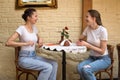 Two friends talking in a cafe. Two girls sitting at a round table and laugh. Friendship concept Royalty Free Stock Photo