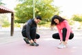 Two friends in their 20s tying their sneakers before running Royalty Free Stock Photo