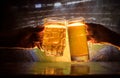 Two friends toasting (clinking) with glasses of light beer at the pub. Beautiful background with blurred view of playing game at t Royalty Free Stock Photo