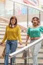 Two friends walking down a stairs with shopping bags in a store Royalty Free Stock Photo