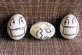 Two frightened eggs in medical masks look at a cracked egg.