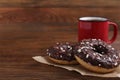 Two frosted donuts with sprinkles and cup of coffee on table, space for text