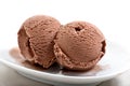 Two frozen balls of chocolate ice cream on  saucer close-up against white background Royalty Free Stock Photo