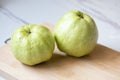Two fruit guava on a wooden cutting board