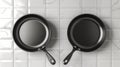 Two frying pans with non-stick coating on a tiled wall Royalty Free Stock Photo