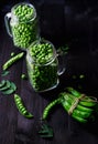 Two full glass jars with fresh mature green peas near bunch. Royalty Free Stock Photo