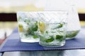 Two full glasses of fresh cool transparent water with ice, lemon and , basil leaves Royalty Free Stock Photo