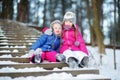 Two funny adorable little sisters having fun together in winter park Royalty Free Stock Photo