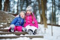 Two funny adorable little sisters having fun together in winter park Royalty Free Stock Photo