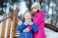 Two funny adorable little sisters having fun together in winter park Royalty Free Stock Photo