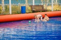 Two funny boys play water football in an inflatable outdoor pool