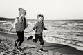 Two funny Caucasian children kids friends playing running on ocean sea beach on sunset Royalty Free Stock Photo