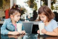 Two funny Caucasian little preschool sisters siblings eat dessert play in cafe. Royalty Free Stock Photo