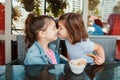 Two funny Caucasian little preschool sisters siblings eat dessert play in cafe. Royalty Free Stock Photo