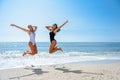 Two funny girls in swimsuit jumping on a tropical beach Royalty Free Stock Photo