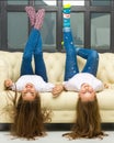 Two funny girls are lying in the studio on the couch upside down Royalty Free Stock Photo