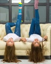 Two funny girls are lying in the studio on the couch upside down Royalty Free Stock Photo